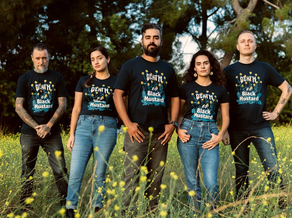 A group of scientists modeling Death to Black Mustard T Shirt in a field of invasive mustard