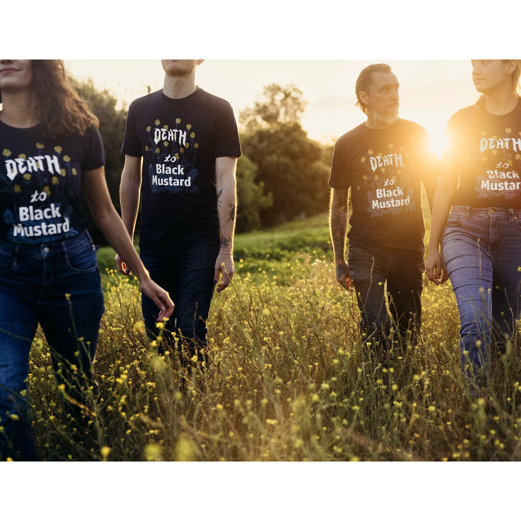 Group of people wearing Death to Black Mustard shirts, looking like a metal band during golden hour