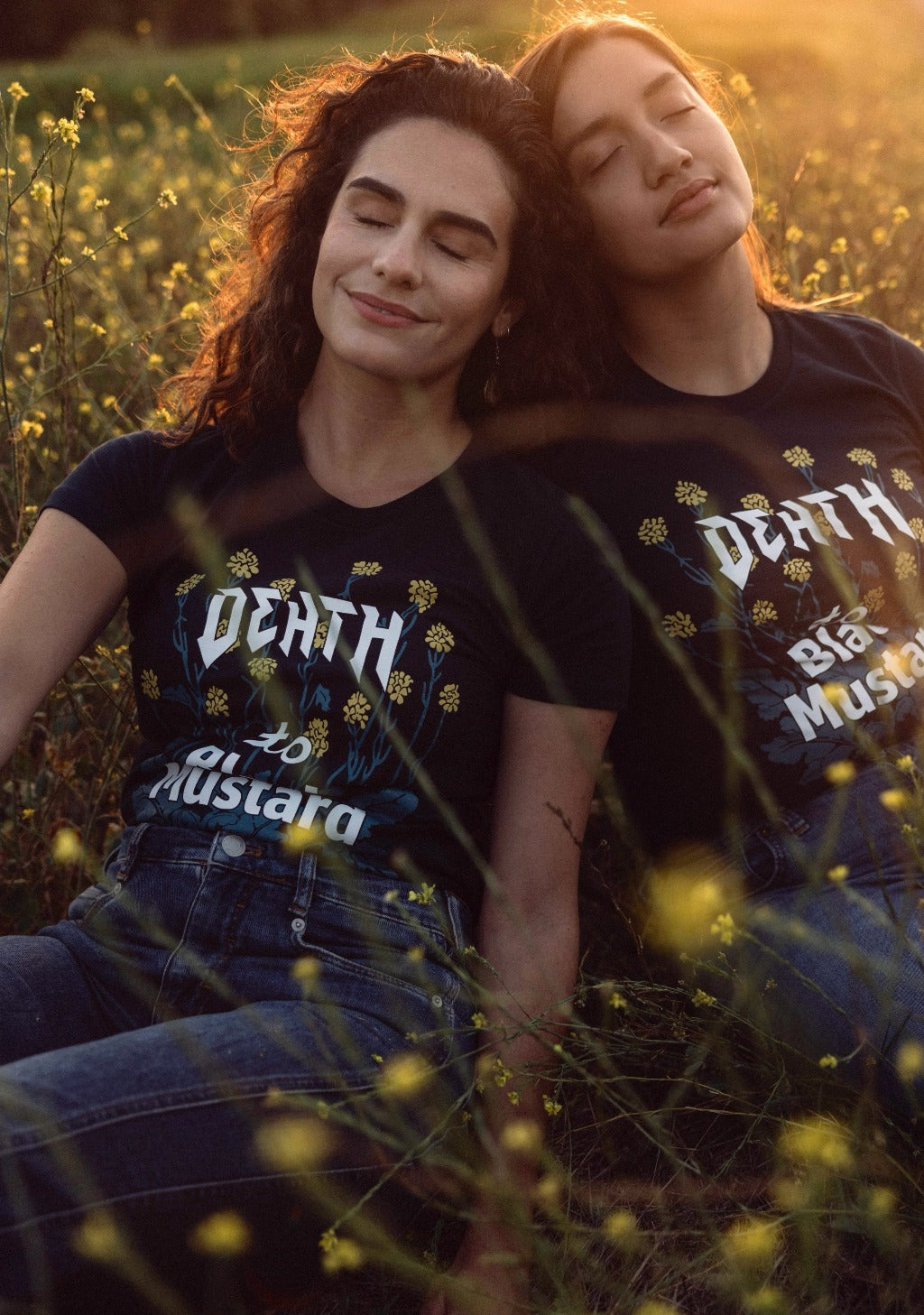 Two women dream in a field of invasive mustard while wearing death to black mustard shirts