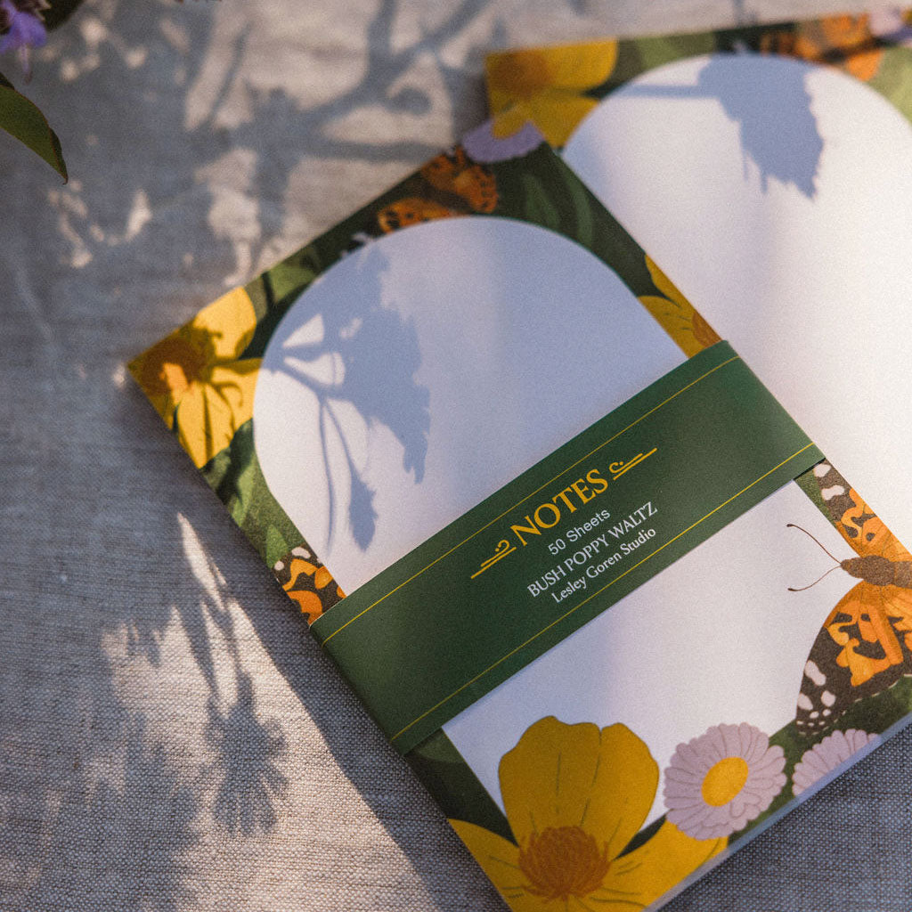 Notepad with floral design and 'NOTES' text on a linen surface